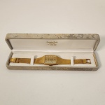 Relógio Omega Constellation Chronometer Automatic, modelo vintage de alto padrão, com caixa em formato tonneau (levemente barrilado), característica muito apreciada no design relojoeiro das décadas de 197080.                                                                                                      A peça apresenta construção integral em ouro 18 quilates, conforme indicado pelos punções visíveis na parte interna do fecho, incluindo a marca 750, padrão internacional que certifica ouro maciço (75% de pureza). Diferentemente de peças apenas folheadas, aqui o metal nobre faz parte estrutural do relógio, elevando significativamente seu valor e desejabilidade.      O mostrador dourado possui acabamento escovado vertical, com índices aplicados e ponteiros finos, mantendo a elegância minimalista típica da linha Constellation. A inscrição Chronometer Automatic confirma que o movimento foi certificado por precisão, um selo reservado a mecanismos ajustados com rigor técnico. A pulseira integrada, também em ouro 18k, segue o mesmo acabamento texturizado da caixa, criando continuidade estética e reforçando a sensação de peça única, quase escultórica.