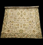 Tapete português de Arraiolos, execução artesanal em lã sobre base de juta, apresentando desenho clássico de influência indo persa. A peça exibe campo central amplo em tonalidade cru, ricamente preenchido por composição vegetalista simétrica, com flores, palmetas, ramos entrelaçados e arabescos estilizados, trabalhados em paleta suave de verdes, ocres, dourados e terracotas. A cercadura larga, em verde musgo, destaca-se pelo motivo contínuo de volutas e elementos florais, característica recorrente nos melhores trabalhos alentejanos. Trabalho tradicional de Arraiolos, de grande presença decorativa, revelando equilíbrio cromático e leitura elegante do repertório ornamental clássico. Apresenta algumas desgastes do tempo. Dimensões: 4,00x 3,00