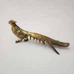 Escultura decorativa representando faisão de cauda longa, executada em bronze, apresentando modelagem detalhada das penas, porte elegante e cauda alongada de grande efeito visual. Trabalho típico da produção decorativa oriental do século XX. Dimensões: 13x32x11 centímetros.
