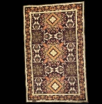 Tapeçaria Casa Caiada intitulada Flor dos Montes, execução artesanal em lã sobre base têxtil, datada de 1979.A composição apresenta desenho geométrico-floral simétrico, característico da produção da Casa Caiada, com paleta quente em tons de marrom, ocre, âmbar e laranja. O motivo central se repete em módulos equilibrados, enquadrados por cercadura decorada com friso de folhagens estilizadas. No verso, inscrição original Flor dos Montes 1979, identificando título e procedência da peça. Dimensões: 1,25 x 0,80