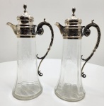 Magnífico par de decantadores em cristal Baccarat. Peças lapidadas com maestria, adornadas com gargalos e alças em prata portuguesa maciça, contrastadas com o punção prata javali, instituído em 1887 para certificar prata de 1º título (916). As monturas, de elegante estilo neoclássico, apresentam volutas, folhas de acanto e cinzelado minucioso, revelando o refinamento técnico das oficinas portuguesas do período. A união entre a transparência pura do cristal Baccarat e o brilho cálido da prata portuguesa cria um conjunto de rara harmonia e prestígio. Dimensões: 32 x 14 x 10 centímetros.