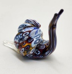 Caracol em vidro artístico Murano trabalhado na técnica tradicional millefiori, evidenciado por sua concha formada por mosaicos multicoloridos em padrões circulares e espiralados. O corpo em vidro translúcido com leve aplicação de pó de ouro complementa a peça, realçando o contraste com a concha elaborada. Escultura inteiramente modelada à mão, apresentando forma fluida, acabamento polido e etiqueta de origem italiana na base. Peça decorativa de excelente presença e forte apelo colecionável, representativa do artesanato vítreo de Murano. Dimensões: 7x8x4 centímetros.