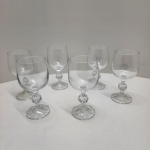Conjunto composto por 6 taças para vinho branco em cristal transparente, todas com corpo liso e haste ornamentada por esfera facetada, detalhe clássico de lapidação decorativa. Base com leve faceteamento radial, produzindo discreto brilho sob a luz. Dimensões:15 x 7 centímetros.