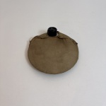 Cantil de formato oval revestido em couro natural envelhecido, com tampa rosqueável em baquelite preta. Estrutura flexível com costura superior e acabamento característico de equipamentos militares de campanha do século XX, apresentando pátina e sinais naturais de uso.