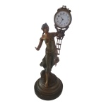 Escultório dito Relógio Pendulete (mysterious clock) em petit bronze europeu, sec. XIX pendûlo sustentando por figura femininna grega com  vestes esvuaçantes, o relógio precisa de troca de bateria. Alt. Alt. 41, Diam. 17 cm.