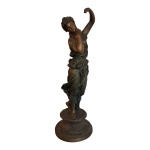 Escultório em petit bronze representando figura feminina representando dama com traje esvoazante,  apoiada em base circular, Alt. 51, Diam. 18 cm.