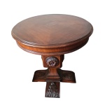 Mesa de apoio em madeira nobre, tampo circular apoiado em haste recordata com medalhão central, apoiado em pernas em cruz entalhada. Alt. 61, Diam.  60 cm.