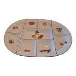 Travessa em porcelana Saler com 7 divisórias decoradas com policromia representando alimentos, 39 x 28 cm.