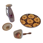 Três peças em porcelana e um prato em cerâmica policromados, o pratos com bordas bicadas, Alt. 25, Diam. 28 cm.