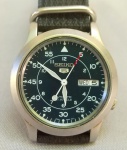 RELÓGIO, um (1) de pulso, marca SEIKO (fundada em 1881 como joalheria pelo próprio Kintaro Hattori, estabelecida em Giza, Tóquio; em 1892 passou a produzir relógios com o nome SEIKOSHA; em 1924 mudou o nome para SEIKO; em 1969 lançou o relógio ASTRON iniciando a era de relógios quartz; em 1980 lançou o relógio quartz automático, ainda em atividade), modelo militar 7S26-02J0, muito usado por pilotos, automático, mecanismo com 21 rubis ou safiras, funcionando, mostrador preto com algarismos arábicos, possui calendário, caixa em aço inox, medindo 37 mm diâmetro, pulseira em material sintético, sinais de uso, vide foto.