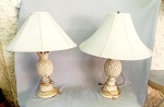 LUMINÁRIAS, par (2) abat-jour para um lume cada, corpo em resina no formato de abacaxi, base cônica em degraus confeccionada em metal, patina na tonalidade branca e sinais de oxidação, parte elétrica não testada, acompanham cúpulas com estrutura aramada vergada, forradas em tecido, medindo 68 cm altura, sinais de uso, vide foto.