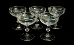 VIDRO, cinco (5) taças de pé alto para champanhe ou espumante, incolores e translúcidas, bojo com singela lapidação vegetalista, fuste em colunetas sobrepostas, base em bolacha, medindo 11 cm altura e 9 cm diâmetro, sinais de uso, vide foto.