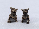 ESCULTURAS, duas (2) miniaturas animalistas, representando CÃES DE FÓ (sagrados animais fantásticos com aparência de leão que guardam os Templos Budistas, termo originário da China, pois fó significa Buda, geralmente representado como casal onde o macho brinca com uma bola que significa a terra e a fêmea protege a cria), confeccionadas em bronze maciço, medindo em média 2,8 cm altura, vide foto.