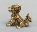 ESCULTURA, uma (1) miniatura representando animal fantástico mistura de cão e leão, confeccionada em bronze maciço, medindo aproximadamente 3 x 2,5 x 1,5 cm, vide foto.