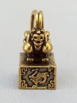 BRONZE, um (1) sinete maciço, representando animal fantástico, com caracteres orientais, medindo 2,5 cm altura, vide foto.