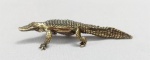 ESCULTURA, uma (1) miniatura animalista representando CROCODILO, confeccionada em bronze maciço, medindo aproximadamente 7,8 cm comprimento, vide foto.