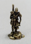 ESCULTURA, uma (1) miniatura figurativa representando GUERREIRO DE PÉ, confeccionada em bronze maciço, medindo aproximadamente 3 cm altura, vide foto.