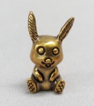 ESCULTURA, uma (1) miniatura animalista representando PIKACHU personagem fictício de Pokémon criado por Atsuko Nishida, confeccionada em bronze maciço, medindo aproximadamente 2,5 cm altura, vide foto.