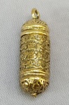 BIJUTERIA ORIENTAL, um (1) pingente porta pílula ou veneno, confeccionado em bronze, ornamentação relevada em caracteres e elementos vegetalistas, tampa rosqueável, medindo aproximadamente 4 cm, vide foto.