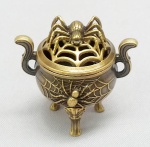 BRONZE, um (1) incensório com tampa e bojo ornados em relevo com aranha na teia, alças na forma de S, pés em carrancas terminando em garras, medindo 5 cm altura, vide foto.