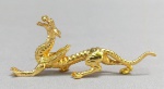 METAL DOURADO, uma (1) escultura no formato de dragão, medindo aproximadamente 8 cm comprimento, vide foto.