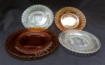 VIDRO, quatro (4) pratos de modelos idênticos com modelagem em caneluras e texturização, tonalidades e tamanhos variados, todos translúcidos, sem marca de manufatura aparente sendo:  1 para bolo, âmbar, medindo 18,5 cm diâmetro; 1 raso, âmbar, bicado na borda visto pela parte de traz, medindo 22,5 cm diâmetro; 2 rasos, incolores, medindo 22,5 cm diâmetro, todos os itens com sinais de uso, vide foto.