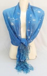 ACESSÓRIO FEMININO, um (1) lenço cachecol, confeccionado em poliéster e flare silk, tonalidade azul, estampado em flores na tonalidade branca, com detalhes metalizados prateados, franjado, medindo 150 x 70 cm mais a franja, usado, vide foto.