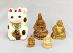 ESCULTURAS, cinco (5) sendo: 3 representando o Deus Hotei (um dos 7 Deuses da Boa Sorte, Fortuna e Felicidade, integrantes do Shichi Fukujin, segundo o Xintoísmo, Mitologia e Folclore Japonês é o deus da felicidade e prosperidade), confeccionados em resina com douração e na tonalidade marfim, um deles é pingente; 1 representando Kuan-Yin (Deusa da misericórdia e compaixão), apresenta-se sentada sobre flor de lótus, confeccionada em resina policromada; 1 representando Maneki Neko (literalmente conhecido como gato que acena, também conhecido como Gato da Sorte, Gato do Dinheiro ou da Boa Sorte é uma escultura asiática comum, na maior parte das vezes feita em cerâmica, que se crê trazer boa sorte ao seu dono. A escultura mostra um gato tradicionalmente um Bobtail Japonês a acenar com uma pata levantada, e é muitas vezes colocado - quase sempre à entrada - de lojas, restaurantes, salas de Pachinko e de outros negócios. No design das figuras, a pata direita levantada supostamente atrai dinheiro, enquanto uma pata esquerda levantada atrai clientes), confeccionada em cerâmica branca ou estuque, policromada, medindo 11 cm altura, todos os itens com sinais de uso, vide foto.
