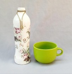 DIVERSOS, dois (2) itens distintos: 1 tigela com alça para cereais matinais, confeccionada em faiança, sem marca de manufatura aparente, tonalidade verde, medindo 12 cm diâmetro e 9 cm altura; 1 vaso em vidro feito artesanalmente com aproveitamento de garrafa, pintado a mão na tonalidade branca, apliques em decalques policromados representado rosas e notas musicais, borda com detalhes em cordoamento, medindo 29 cm altura, ambos com sinais de uso, vide foto.