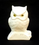 ESCULTURA, uma (1) representando coruja pousada em tronco, confeccionada em faiança, tonalidade branca, esmaltação vítrea, olhos em vidro, pequeno bicado ou falha na esmaltação em uma das orelhas, medindo 14,5 cm altura, vide foto.