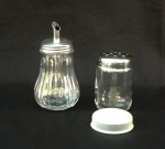 VIDRO, dois (2) itens, incolores e translúcidos com tampa em aço inox: 1 açucareiro, medindo 14 cm altura; 1 polvilhador, medindo 9 cm altura, ambos com sinais de uso, vide foto.