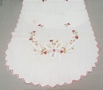 CAMA E MESA, um (1) caminho confeccionado em tecido de linho, tonalidade branca, ornado com bordado floral e crivos, medindo 90 x 40 cm, usado e com manchas, vide foto.