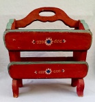 DIVERSOS, um (1) revisteiro, confeccionado em madeira, pintado a mão nas tonalidades vermelha e verde, com singelos florais policromados, possui pequenas perdas e defeitos, sinais de uso, medindo 44,5 cm comprimento, vide foto.