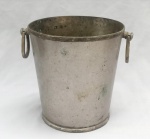 METAL PRATEADO, uma (1) champanheira ligeiramente obcônica, ornamentação da borda e base, reforçadas e relevadas em frisos intercalados por X e flores, alças idem, padrão Império Napoleônico, sem marca de manufatura aparente, medindo 21 cm altura e 19,5 cm diâmetro, sinais de uso e mossas, vide foto.