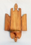 ARTE SACRA, uma (1) peanha para fixação em parede, confeccionada em madeira, possui duas portinholas, dobradiças em metal, medindo 53 cm altura, sinais de uso, vide foto.