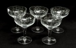DEMI CRISTAL, cinco (5) taças de pé alto para champanhe ou espumante, incolores e translúcidas, bojo lapidado em sulcos e estrelas, fuste cilíndrico, base em bolacha, medindo 12 cm altura, sinais de uso, vide foto.