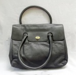 ACESSÓRIO FEMININO, uma (1) bolsa confeccionada em couro, tonalidade preta, NEY ORBER ACCESSORIES, forrada, possui divisões, alças duplas de mão, fecho giratório, metálico, estilo Satchel, medindo 38 x 30 x 14 cm, sinais de uso, demanda limpeza, vide foto.