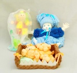 BRINQUEDOS, três (3) itens: 1 boneca, anos 90, confeccionada em lã, tonalidades de azul, rosto, pés e mão em polímero, medindo aproximadamente 25 cm; 1 boneca artesanal, confeccionada em E. V. A. (polímero emborrachado, atoxico e flexível), policromada, apoiada em uma base, cabeça quase solta, medindo 25 cm; 1 artesanato decorativo, confeccionado em toalhas e soft, papel scrapbook, tendo como personagem central porquinha com filhotes dentro de uma cesta trançada e decorada com mini flores e fitas em cetim, possui perdas, todos os itens usados, vide foto.
