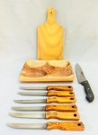 EQUIPAMENTO PARA COZINHA, nove (9) itens: 6 facas de serra para churrasco, lâminas em aço, cabo em madeira, marca BÚFALO, medindo 21,5 cm comprimento; 1 faca para churrasco, lâmina em aço, marca WESTERN, cabo em polímero, medindo 32,5 cm comprimento; 1 tábua em madeira maciça, medindo 29 x 14 cm; 1 petisqueira em madeira maciça, medindo 23 x 17,5 cm, todos os itens com sinais de uso, vide foto.