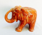 CERÂMICA E FAIANÇA, uma (1) escultura representando elefante, esmaltação vítrea na tonalidade caramelo, faltam a s presas, perdas nos pés traseiros, sem marca de manufatura aparente, medindo 29 cm comprimento, vide foto.
