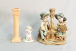 DIVERSOS, três (3) castiçais distintos: 1 confeccionado em louça, relevado em flores e laçarote, policromado, possui perdas, sem marca de manufatura aparente, medindo 8 cm altura; 1 na forma de coluna canelada, base trapezoidal, capitel jônico, confeccionada em resina marmorizada, medindo 18 cm altura; 1 representando casal ao lado de coluna, confeccionado em estuque policromado, possui falhas e perdas, medindo 18,5 cm altura, todos os itens com sinais de uso, vide foto.