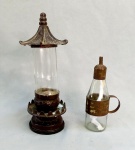 DIVERSOS, dois (2) itens distintos: 1 frasco de perfume, cilíndrico, vazio, confeccionado em vidro, incolor e translúcido, base e tampa em metal representando pagode, medindo 27,5 cm altura; 1 lamparina a pavio, confeccionada com aproveitamento de garrafa, incolor e translúcida, monture em folha de flandres com sinais de oxidação, medindo 18,5 cm altura, ambos com sinais de uso, vide foto.