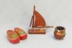 DIVERSOS, quatro (4) souvenires confeccionados em madeira: 1 de Rio das Ostras representando barco a vela; 1 cinzeiro de Espírito Santo, lembrança do Convento da Penha, formato de caldeirão; 2 (par) tamancos holandeses, medindo a maior peça 15 cm altura, vide foto.