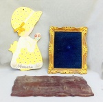 DIVERSOS, três (3) itens: 1 porta chaves para fixação em parede, confeccionado em madeira, medindo 35 x 16 cm; 1 moldura confeccionada em madeira, patina dourada, possui perdas, parte central forrada em tecido azul, medindo 23 x 29 cm; 1 toalheiro para fixação em parede, confeccionado em placa de eucatex, representando silhueta de menina, pintada a mão em policromia, traz a legenda Mariana, medindo 40 cm, todos os itens com sinais de uso, vide foto.