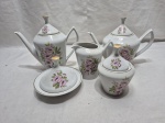 Jogo de servor chá, café com 5 peças em porcelana Pozzani floral com friso ouro. Composto de 2 bules, leiteira, açucareiro e manteigueira. Medindo o bule maior 14cm de altura.