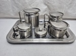 Jogo de servir chá, café com 6 peças em aço inox. Composto de 2 bules, leiteira, açucareiro, manteigueira e bandeja. Medindo a bandeja 42cm x 30cm.