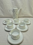 Jogo de bule com 6 xícaras de chá em porcelana, sendo o bule floral e as xícaras com friso prata. Medindo a xicara 8cm x 5cm de altura.