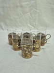 Jogo de 6 copinhos de shot em demicristal com suporte em metal dourado. Medindo 6,5cm de altura.