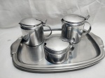 Jogo de servir chá, café com 4 peças em aço inox. Composto de bule, leiteira, açucareiro e bandeja. Medindo a bandeja 41cm x 28cm.