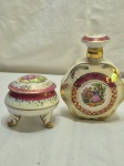 Lote de caixa e garrafa em porcelana furtacor com cena galante e friso ouro. Medindo a garrafa 13,5cm de altura, com bicado.
